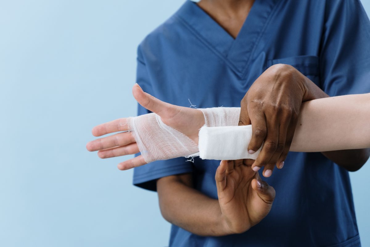 Gauze bandage being wrapped around a hand, illustrating wound-care essentials